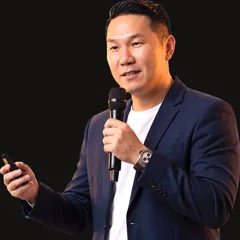 Aaron Chong speaking on stage with a microphone